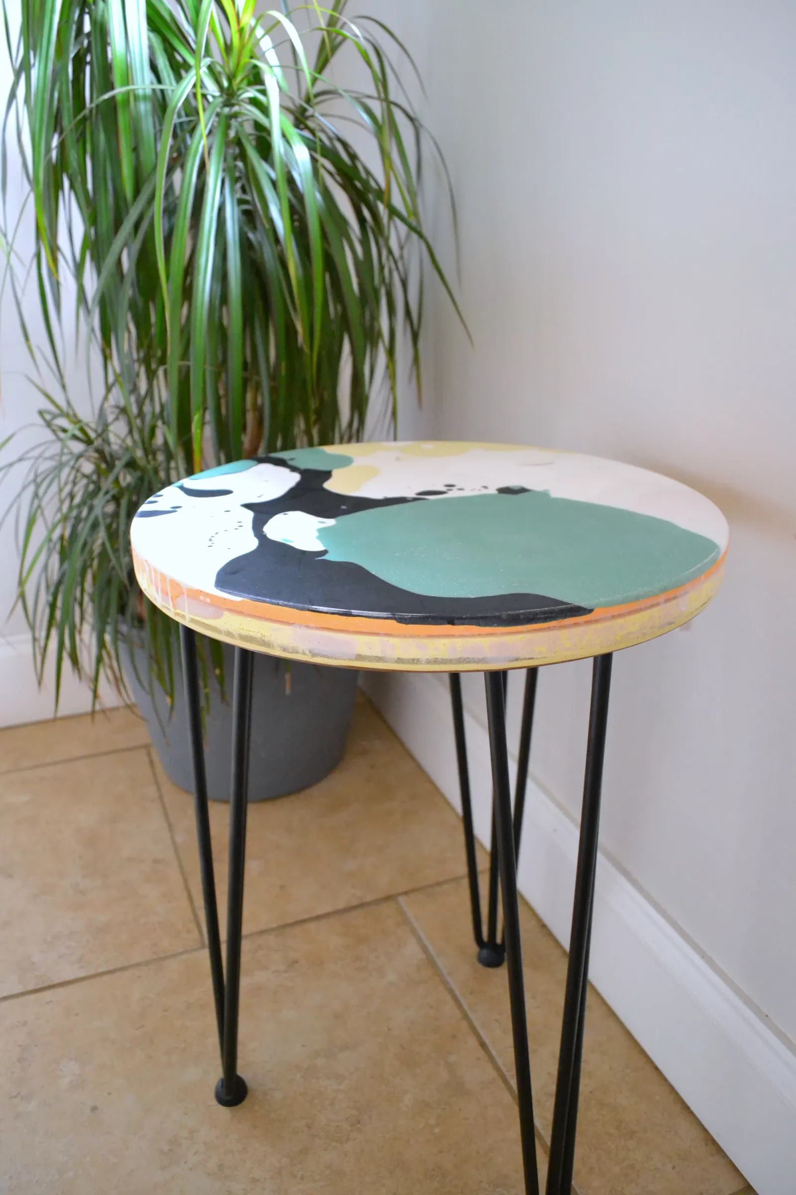 Green, black and white round studio table made from workshop offcuts.