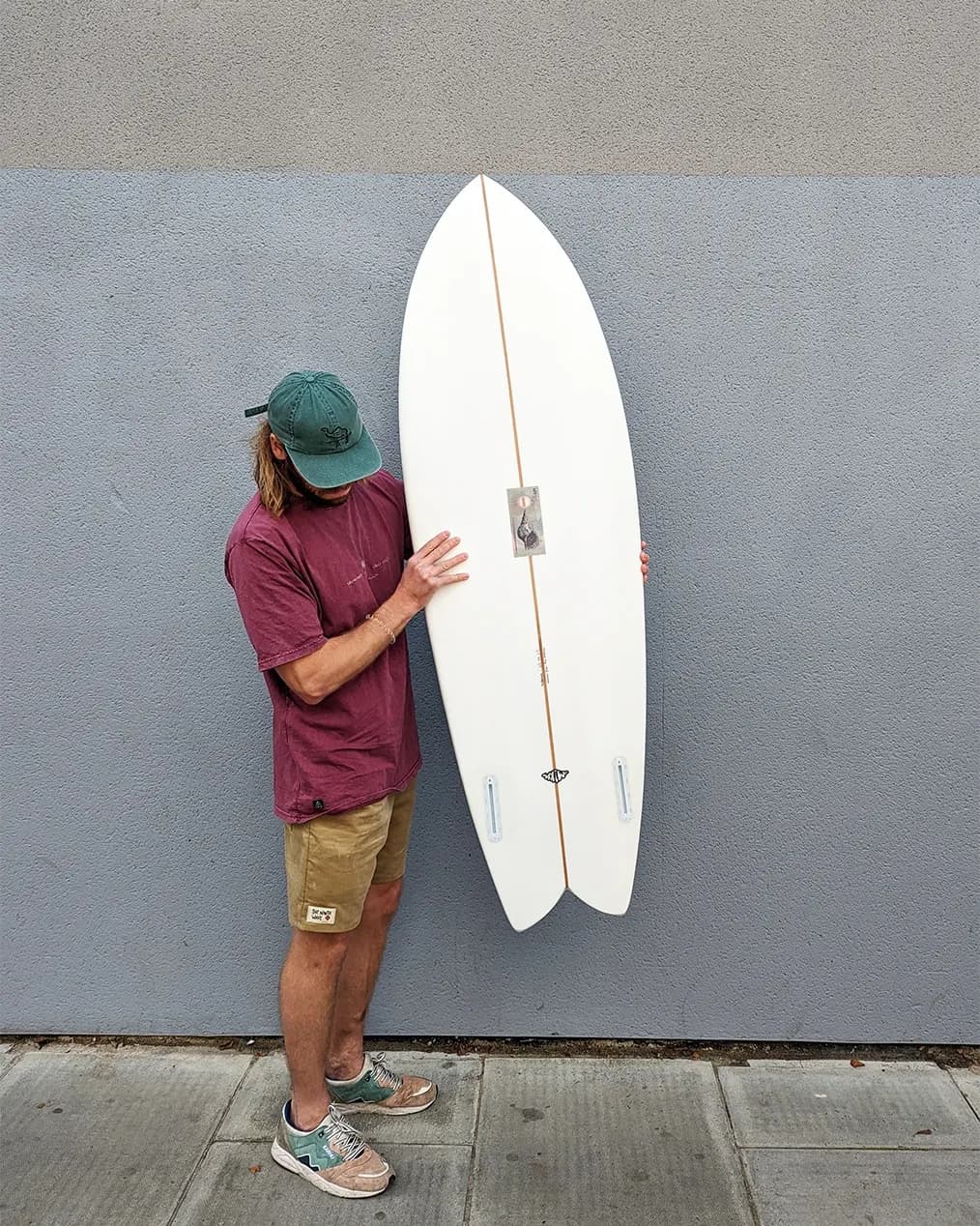 A Whitburn Nudibranch surfboard on the ground.